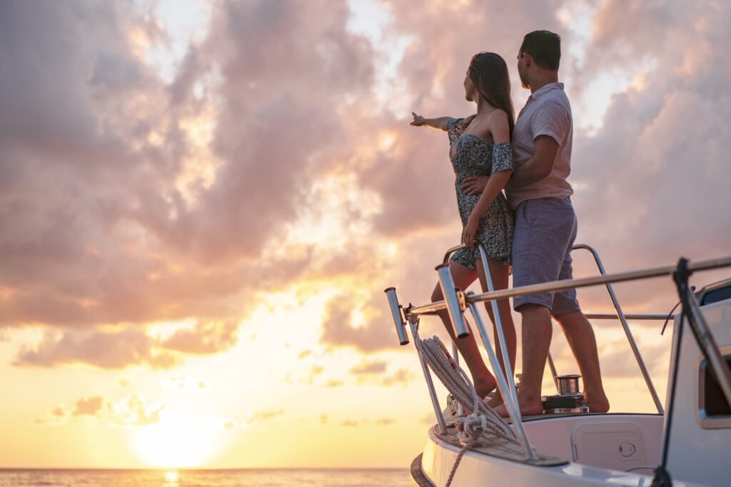 Beautiful couple looking at sunset from the yacht